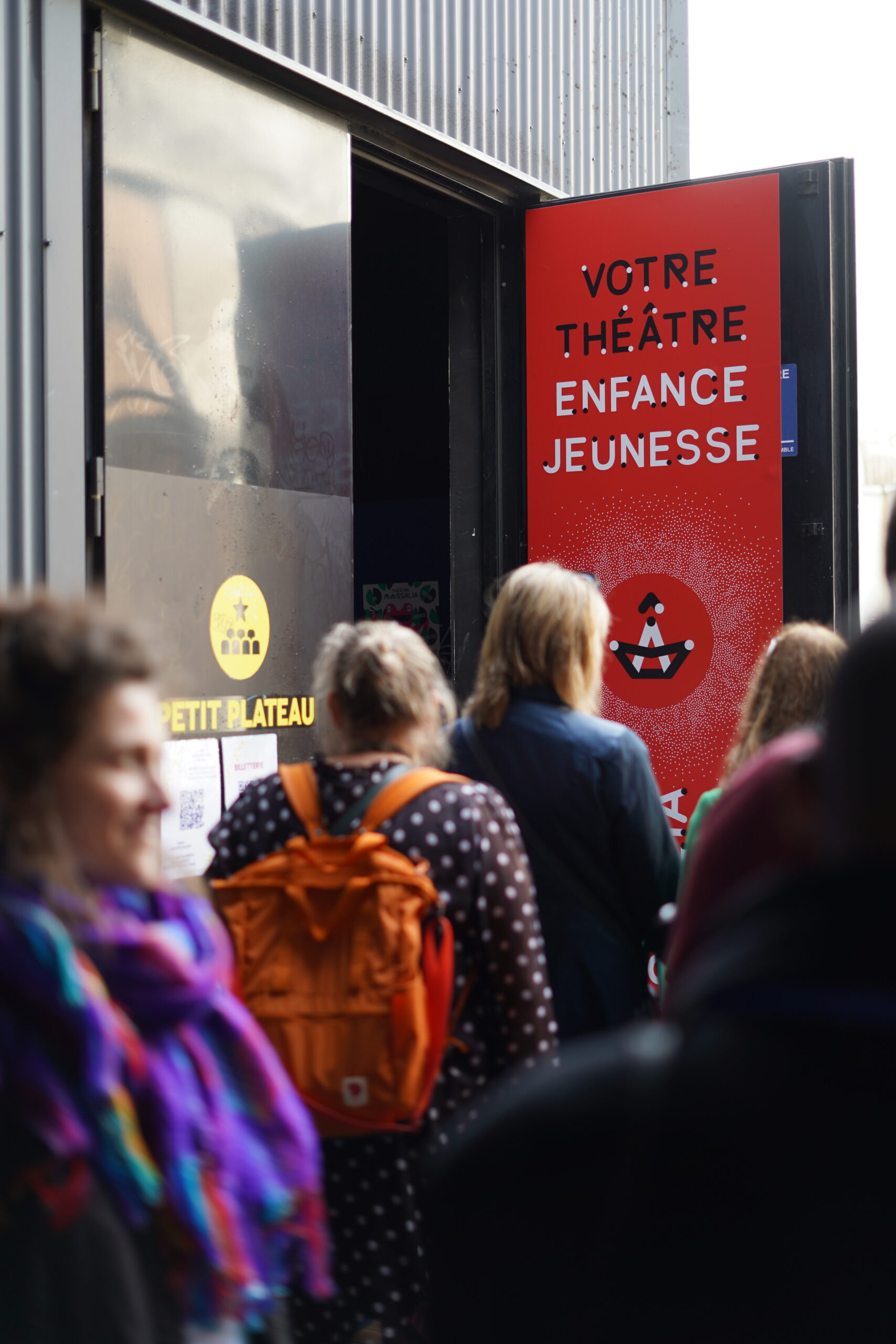 Photo, du public de dos qui rentre dans le théâtre Massalia